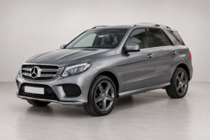 Серый Mercedes-Benz GLE на светлом фоне, вид спереди и сбоку.