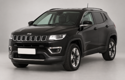 Тёмный Jeep Compass на светлом фоне, вид спереди и сбоку.