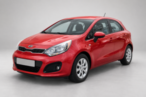 Красный хетчбэк Kia Rio, вид спереди и сбоку на светлом фоне.