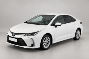 Белый седан Toyota Corolla на светлом фоне, вид спереди и сбоку.